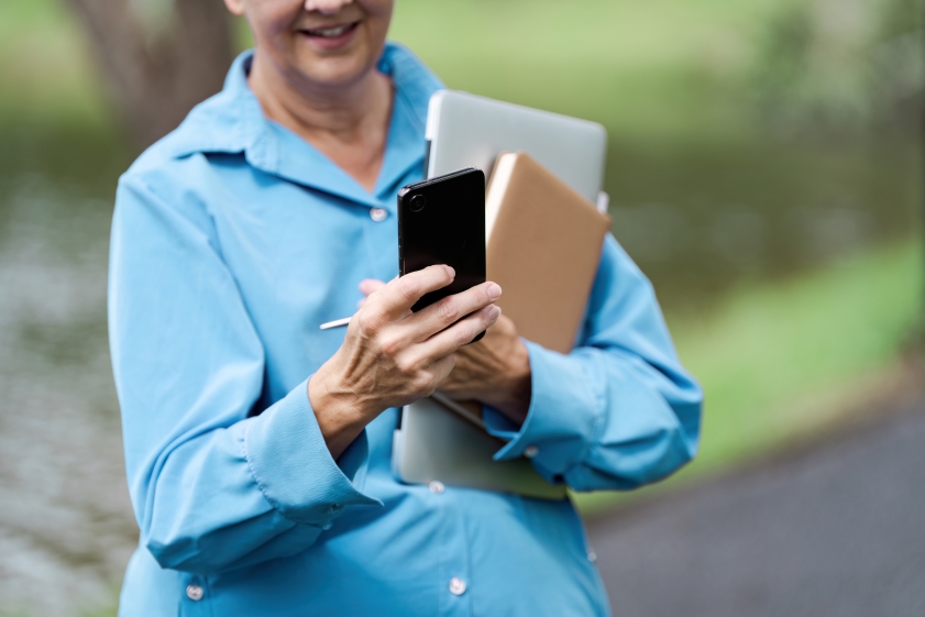 12.31 CC Photo Person reviewing 2024's top financial lessons article on iPhone.