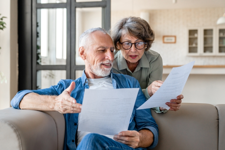 Couple looking over documents, discussing changes to retirement planning