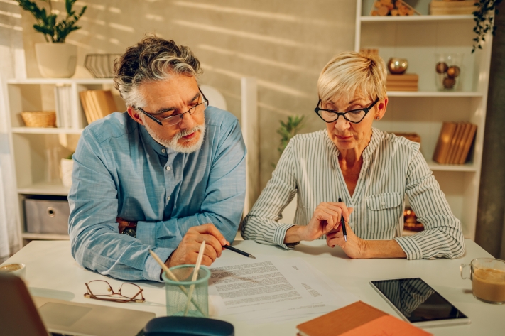 Couple sitting at table reviewing finances and market volatility
