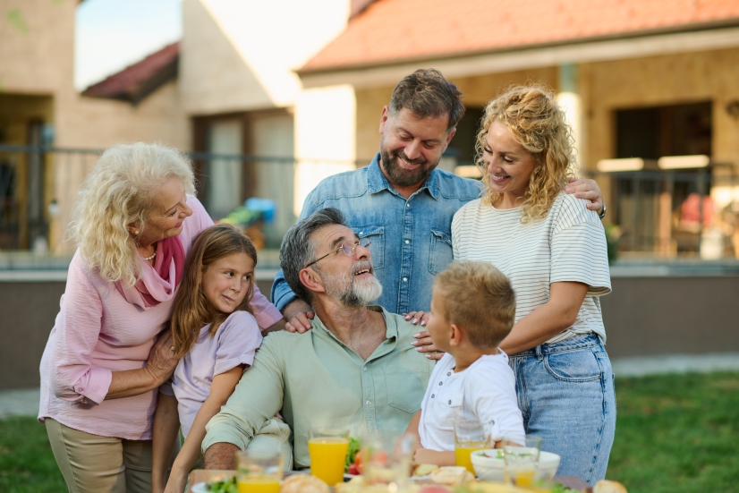 Multigenerational family gathered at the head of a picnic table